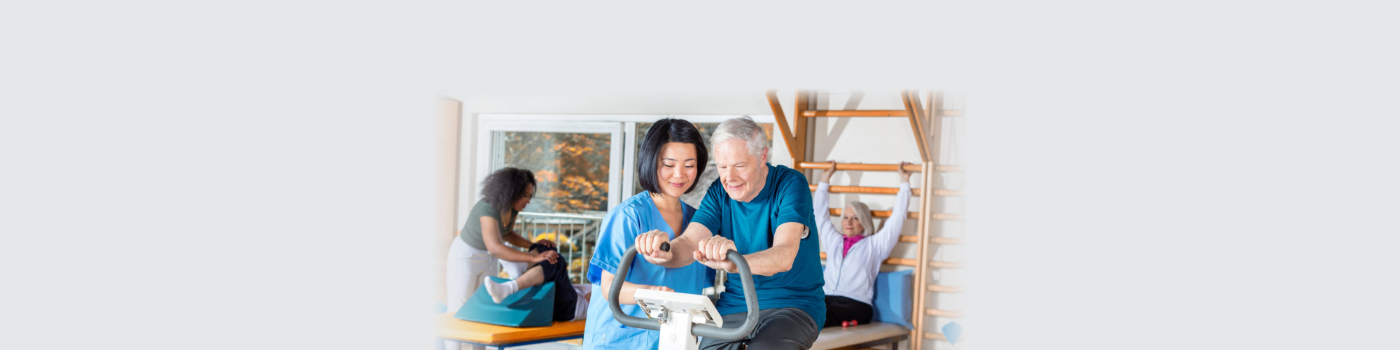 Asian nurse helping elder man in hospital gym